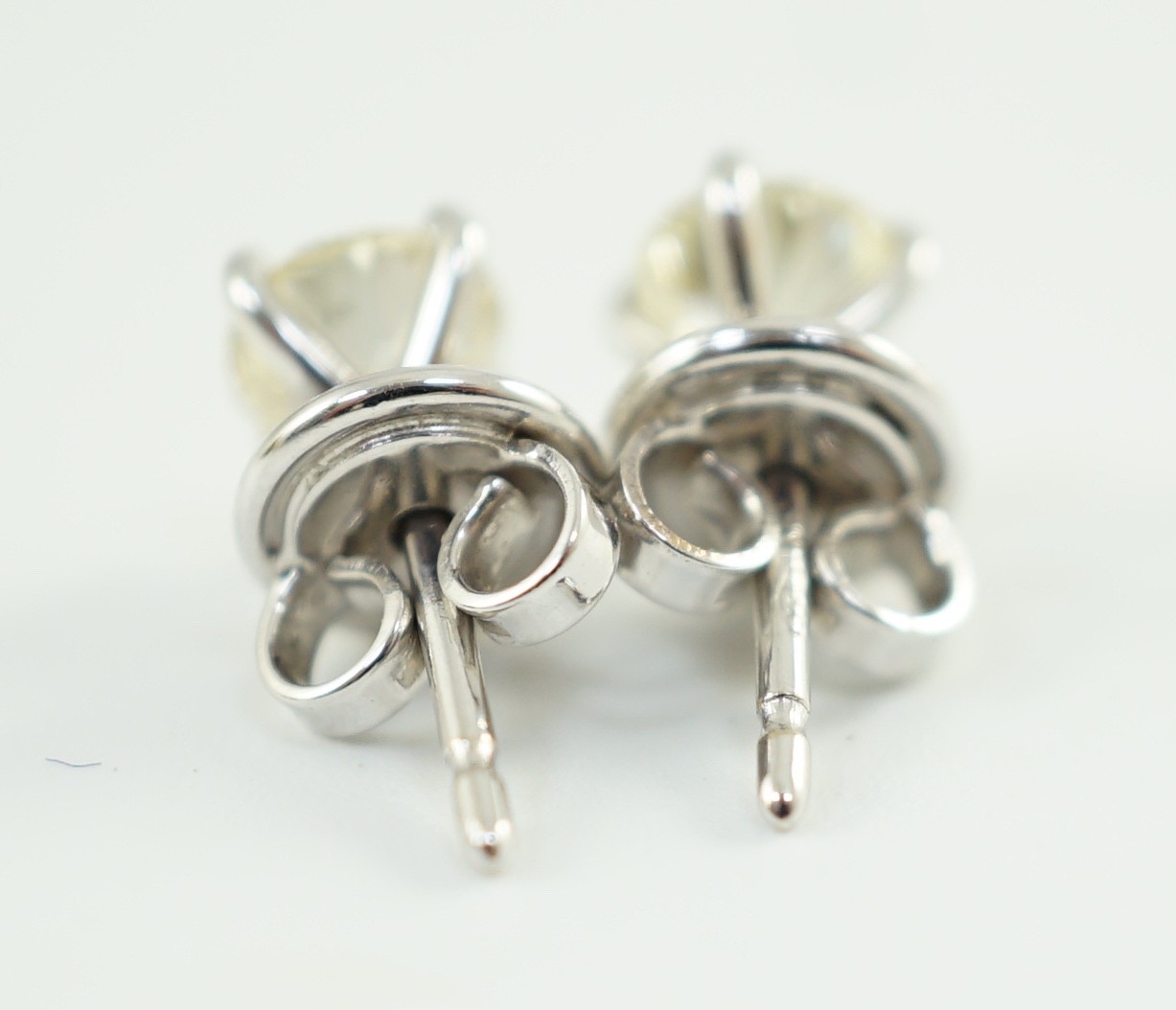 A pair of 18ct white gold and solitaire diamond set ear studs